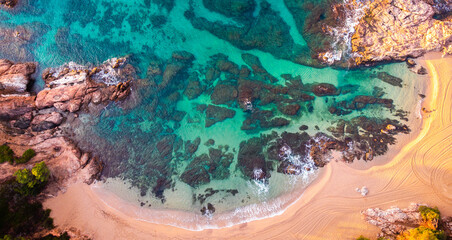 Aerial view of Sa Conca beach, Costa Brava, Catalunya, Mediterranean sea coast, Spain. Beach background with transparent turquoise blue water. Summer tourism. Beach vacations.