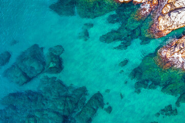 Aerial view over rocks landscape and blue turquoise sea at Costa Brava, Catalonia, Spain. Artistic summer background of the mediterranean coast. Summer conceptual background. Beach tourism vacations.