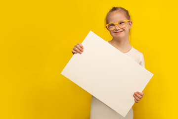 Girl with Down Syndrome holding a white canvas with space for text