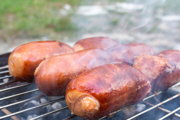 Close up barbecue grill with meat and sausages cooking during summer garden party