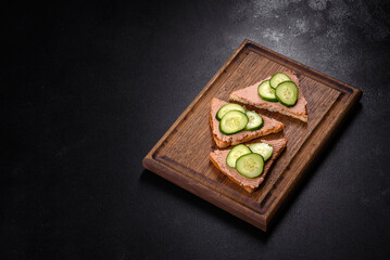 Delicious fresh sandwich with chicken liver pate with crispy toast, butter and cucumber
