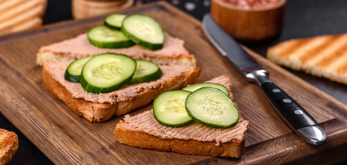 Delicious fresh sandwich with chicken liver pate with crispy toast, butter and cucumber