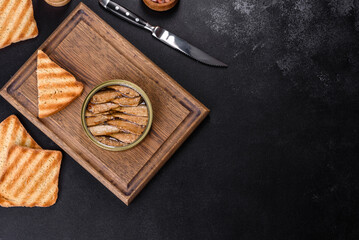 Delicious fresh sandwich with sprats with crispy toast, butter and cucumber