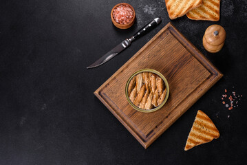 Delicious fresh sandwich with sprats with crispy toast, butter and cucumber