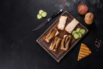 Foto op Aluminium Delicious fresh sandwich with sprats with crispy toast, butter and cucumber © chernikovatv