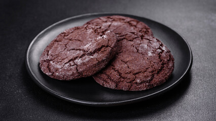 Delicious fresh chocolate biscuits on a dark concrete background with Christmas toys