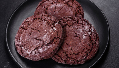 Delicious fresh chocolate biscuits on a dark concrete background with Christmas toys