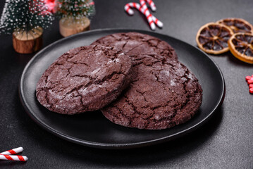 Delicious fresh chocolate biscuits on a dark concrete background with Christmas toys