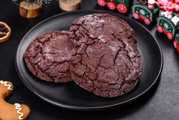 Delicious fresh chocolate biscuits on a dark concrete background with Christmas toys