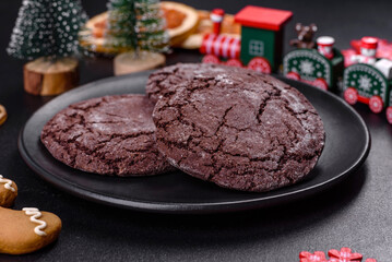 Delicious fresh chocolate biscuits on a dark concrete background with Christmas toys