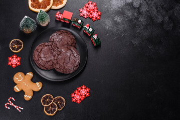 Obraz na płótnie Canvas Delicious fresh chocolate biscuits on a dark concrete background with Christmas toys