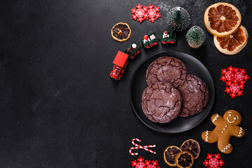 Delicious fresh chocolate biscuits on a dark concrete background with Christmas toys