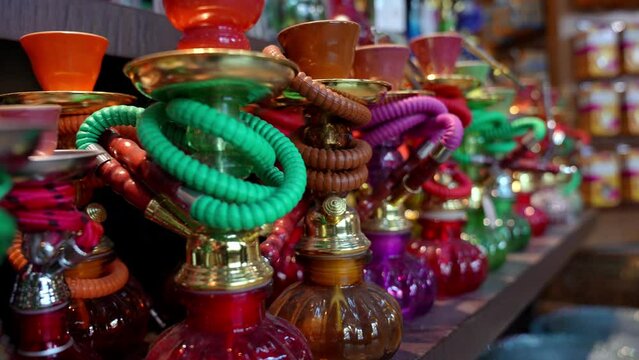 Multicolored hookahs with smoking equipment on display at market for sale. Various types of hookahs in store in Dubai.