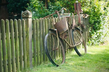 Rostiges Fahrrad am Gartenzaun