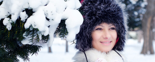 Portrait of young smiling woman in snow of winter forest