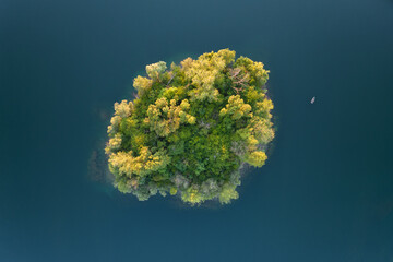 Aerial View on a little island and a small boat in the quarry lake Binsfeldsee at Speyer in Germany.