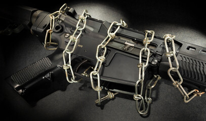 Chain around an assault rifle on a black background