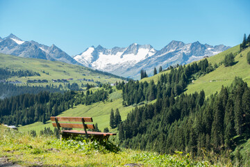 Ruhebank mit Aussicht auf die Berge Österreichs - obrazy, fototapety, plakaty