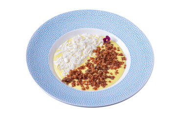Yellow sauce with cheese, pieces of meat and violets