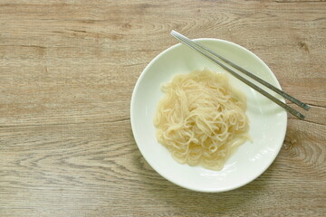 dry Vietnamese rice noodles or Pho with soup on plate