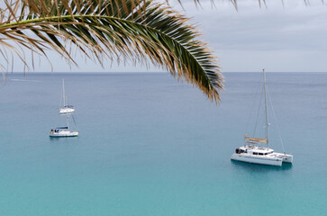 sailing catamaran in the turquoise sea on a cloudy day