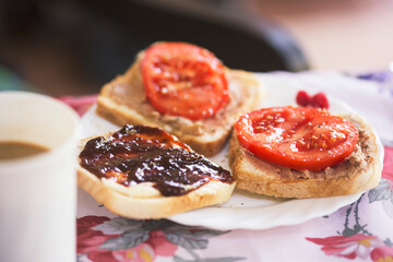 Toasts with liver sausage and tomatoes and plum jam and coffee 