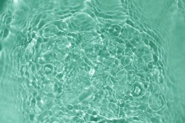 Soft focus lite green blue gray cosmetic moisturizer floral water, micellar toner, or emulsion abstract background. Reflections of  scattered sun texture.