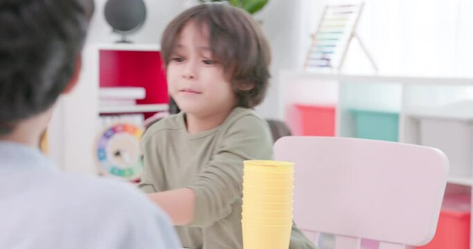 In the kindergarten classroom, children are playing with stacking cups. Concept of education and learning. school life style
