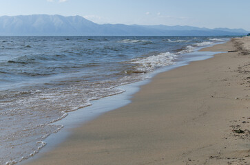 Beautiful seascape. The waves of Lake Baikal wash the sandy shore.