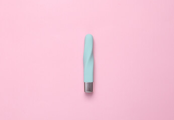 Blue clitoral vibrator on a pink background. Minimal sex still life