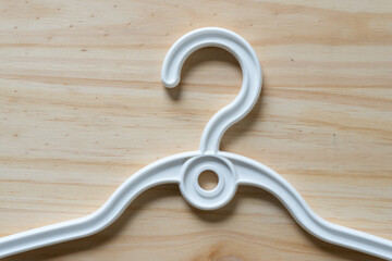 white plastic coat hanger on a wooden surface