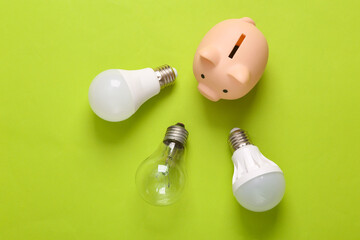 Save money concept. Piggy bank with led bulbs on a green background