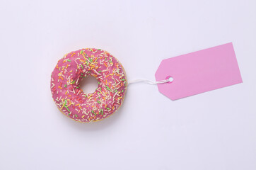 Glazed donut with price tag on white background