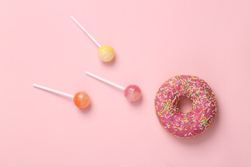 Donut lollipop on pink background. Allegory of fertilization of the egg. top view
