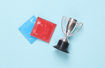 Macho, alpha male. Condoms with winner cup on pink pastel background