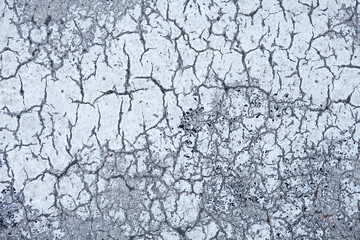 Cracked white and gray asphalt texture. Damaged asphalt ground background. Abstract aged road pattern detail. Cracked sidewalk background. Copy space