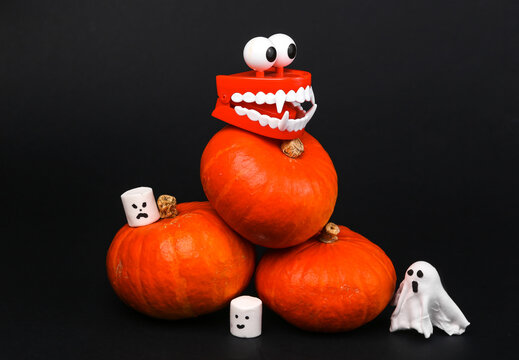 Orange pumpkins and halloween decor, toys isolated on black background