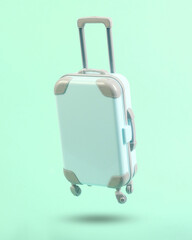 Mini travel luggage soaring on a blue background. Minimalism travel concept