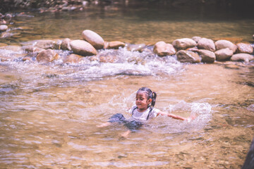 girls having fun playing in the waterfall