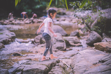 girls having fun playing in the waterfall