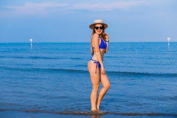 sexy woman in bikini standing in water in sea