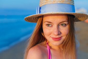 Close-up portrait of girl with freckles in stylish boater