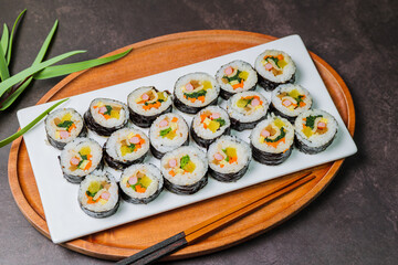 Korean food Gimbap : Rice seasoned with salt and sesame oil and rolled up in a sheet of roasted gim (dried laver) with spinach, carrots, and pickled white radish. The long roll is sliced and served in