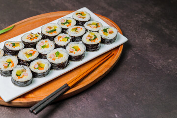 Korean food Gimbap : Rice seasoned with salt and sesame oil and rolled up in a sheet of roasted gim (dried laver) with spinach, carrots, and pickled white radish. The long roll is sliced and served in