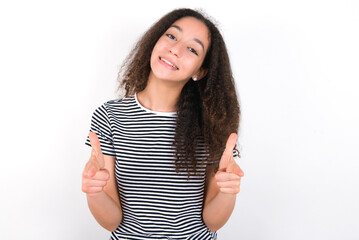 young beautiful girl with afro hairstyle wearing striped t-shirt over white wall directs fingers at camera selects someone. I recommend you. Best choice