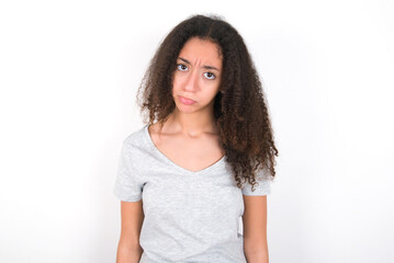 young beautiful girl with afro hairstyle wearing grey t-shirt over white wall depressed and worry for distress, crying angry and afraid. Sad expression.