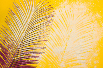palm leaf on with sand on it and in the sand palm leaf trace, yellow background, creative summer...