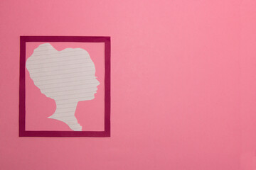 pink frame with paper woman silhouette with lines on the left side of the background, right part copy space, creative modern design, woman on the pink background