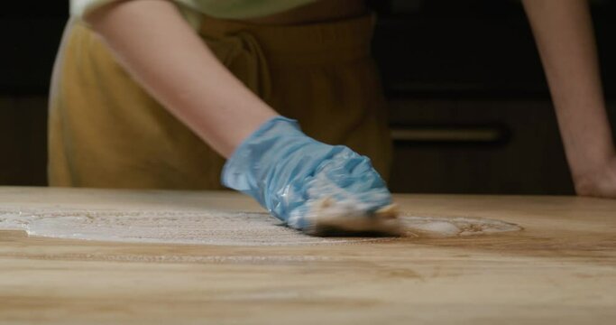 process of cleaning the wooden countertop of the kitchen table