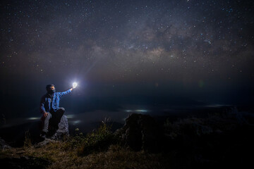 Obraz na płótnie Canvas Man sit down on stone at night. Milky way galaxy at night.